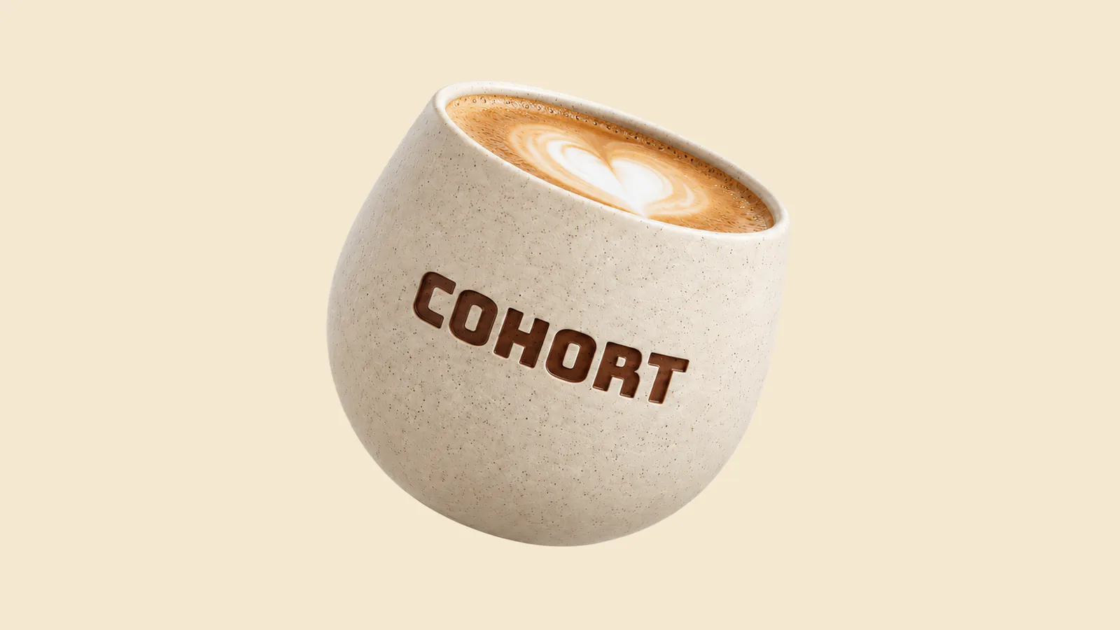 Speckled cream ceramic Cohort cup with a latte, tilted, with the Cohort wordmark