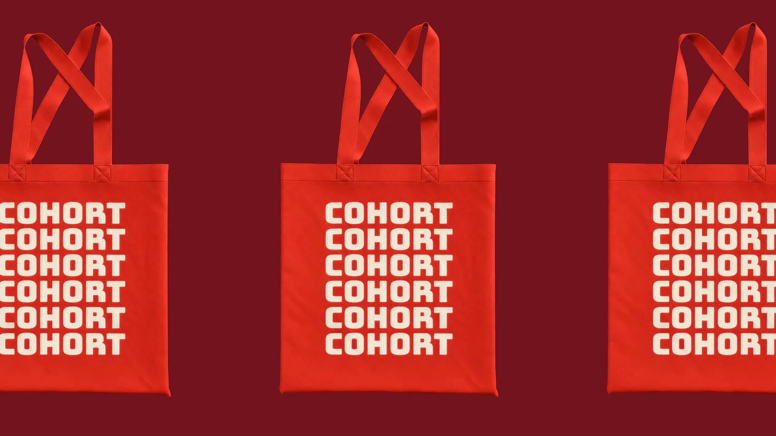 Three red tote bags with the Cohort wordmark repeated down the front