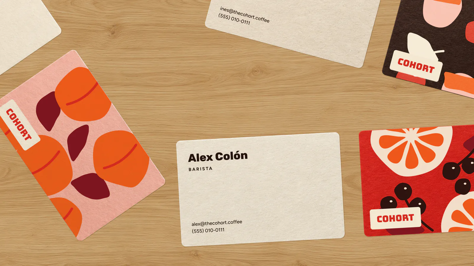 Cohort business cards and fruit-pattern cards on a wooden table